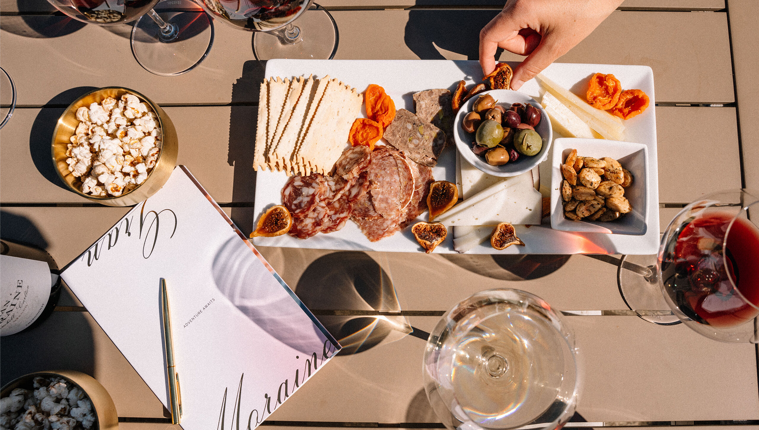 Hand reaching for Hors d’Oeuvres and nosh plate on outdoor table at Gran Moraine.